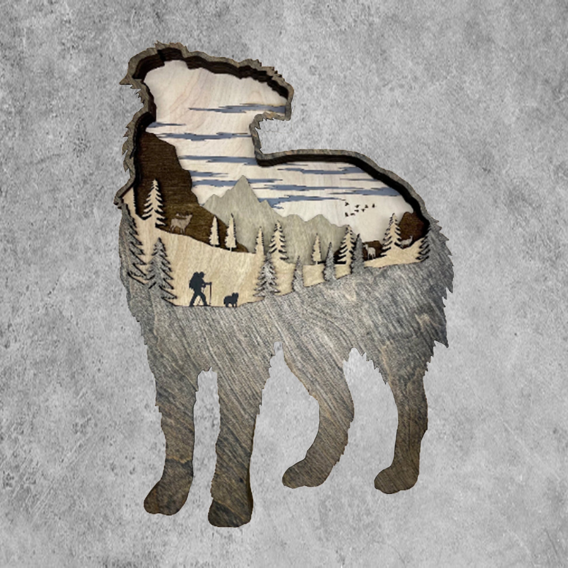 This 3D wood Australian Shepherd design houses five layers of wood, which showcase the mountains, wildlife, flora, fauna, and a hiker with their pup.